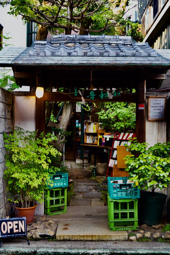 Charming entrance to a traditional Japanese shop, beautifully surrounded by lush greenery.